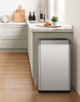 EKO stainless steel trash can in a kitchen setting with a countertop and cabinets.